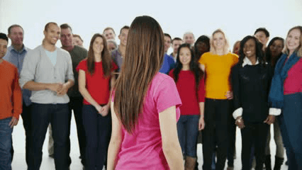 Women standing infront of crowd of peers