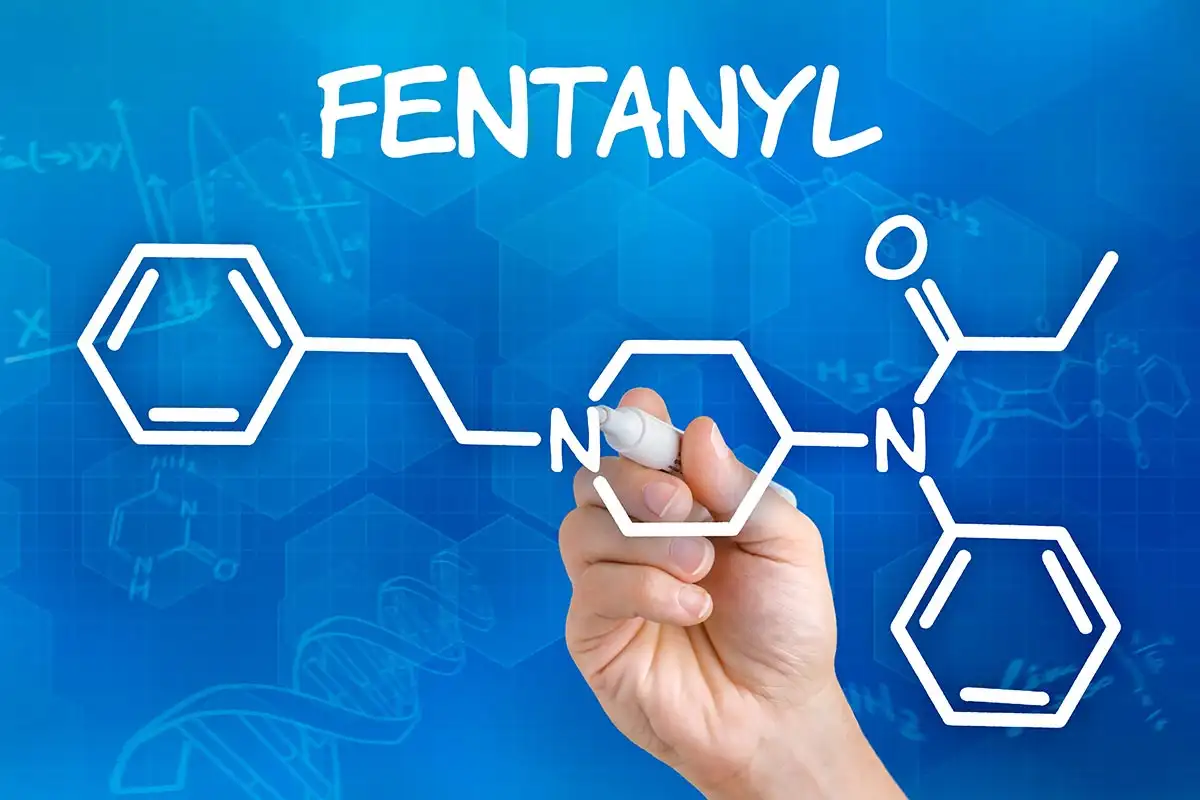 Fentanyl Addiction Treatment Hand with pen drawing the chemical formula of fentanyl