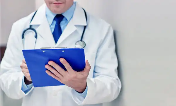 doctor-holding-a-folder-writing-prescription