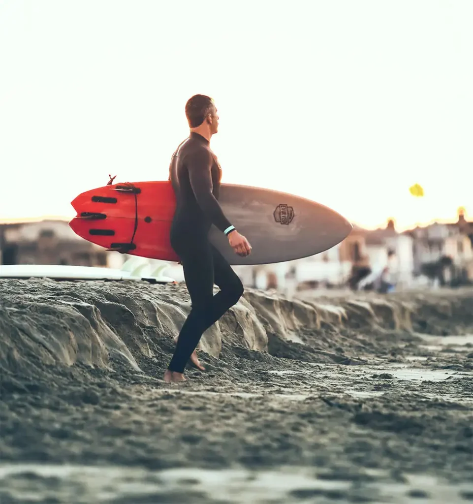 male client walking in the beach after surfing in newport beach california drug and alcohol rehab (1)