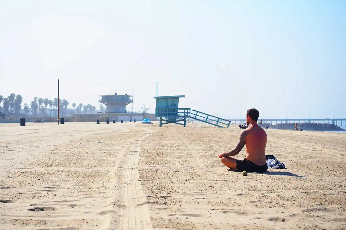 man sitting on beach sand in Los Angeles California