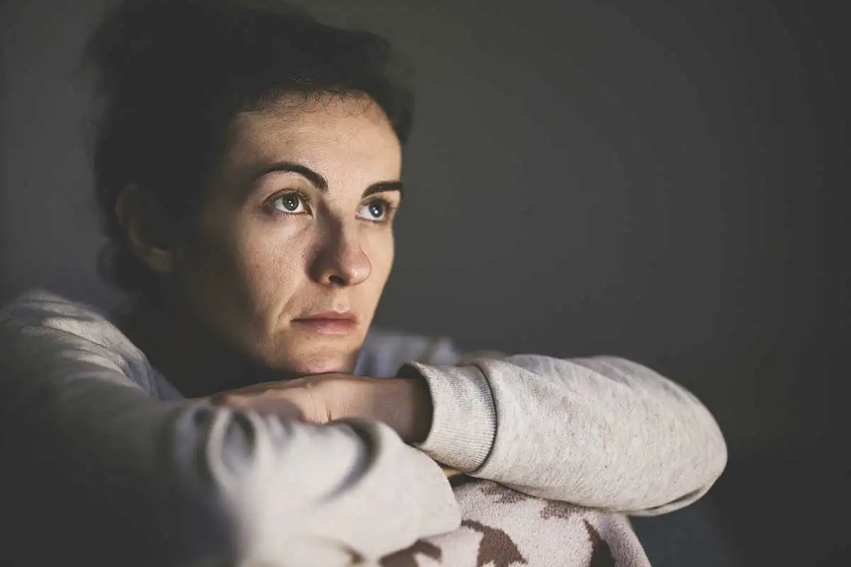 woman-sitting-in-the-corner-of-her-room-very-sick